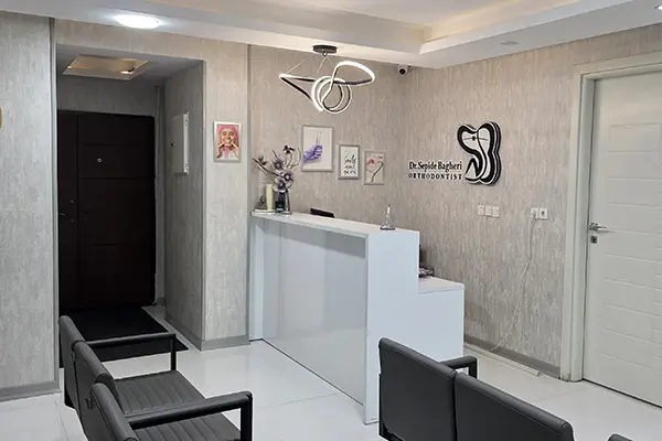 فضای نشیمن سالن انتظار مطب با گیاهان و قفسه کتاب